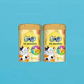 GOS Infant Formula Milk Powder In Yellow Cans With Cartoon Cow On Light Blue Background
