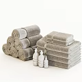 Soft Neutral Color Cotton Bath Towels Stacked And Rolled With Bath Product Bottles