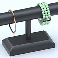 Elegant Gold Thin Bracelet And Green Beaded Jewelry On Black Display Stand