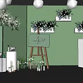 Elegant Photo Check-in Spot With Green Wall Flower Arrangements Easel Logo And White Pillars