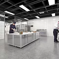 Commercial Catering Kitchen Interior With Chefs Working At Stainless Steel Worktables And Commercial Appliances