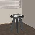 Round Three Legged Wooden Stool With Books On Indoor Wooden Floor Near Window