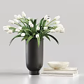 White Tulips in Black Vase with Green Leaves and White Bowl on Stacked Books