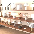 Collection Of Modern Table Lamps With Various Shapes And Materials On Wooden Shelves