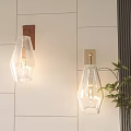 Modern Wall Sconces With Clear Glass Shade And Metal Base Mounted On White Tile Wall