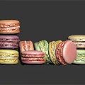 Colorful Macarons Stacked And Scattered On Dark Background With Vibrant Hues