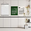 Green And White Calendars Hanging On White Wall With Potted Plant And Bookshelf