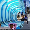 Surfing Themed Illuminated Wave Structure With People Taking Photos In Urban Night View
