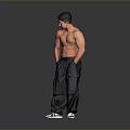A Shirtless Muscular Man In Dark Cargo Pants And Black White Sneakers Against Grey Background