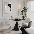 Modern Round Black Dining Table With White And Black Chairs And Green Plant