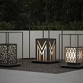 Three Outdoor Lights With Different Hollow Designs Black Frames One Illuminated Green Plants Grey Ground