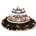 Three Tiered Cupcake Stand With Assorted Cupcakes And Red Green Leaf Decorations