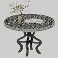 Round Black White Patterned Dining Table With Curved Metal Legs And White Vase Green Plant