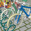 Colorful Bicycles Parked at Outdoor Bike Rack on Brick Paved Surface