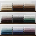 Soft Stacked Grey And White Towels With Striped Accents On Wooden Surface