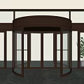 Brass Frame Revolving Door With Glass Panels And Green Plant On Polished Marble Floor