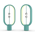 Two Turquoise Oval Shaped Table Lamps With Yellow Light And Silver Spherical Decorations