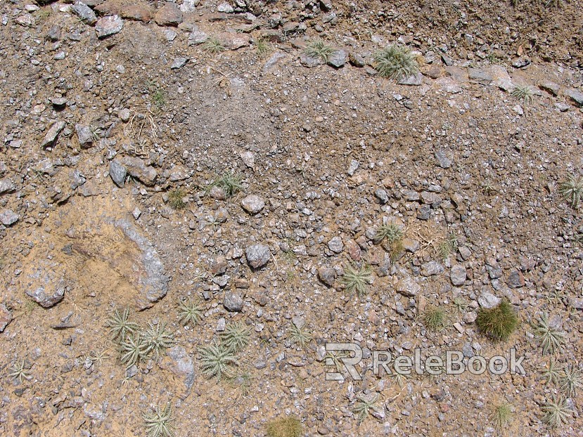 The image depicts a close-up of gravel, showcasing an assortment of small, irregularly shaped stones with various hues of gray, brown, and black, set against a contrasting background.