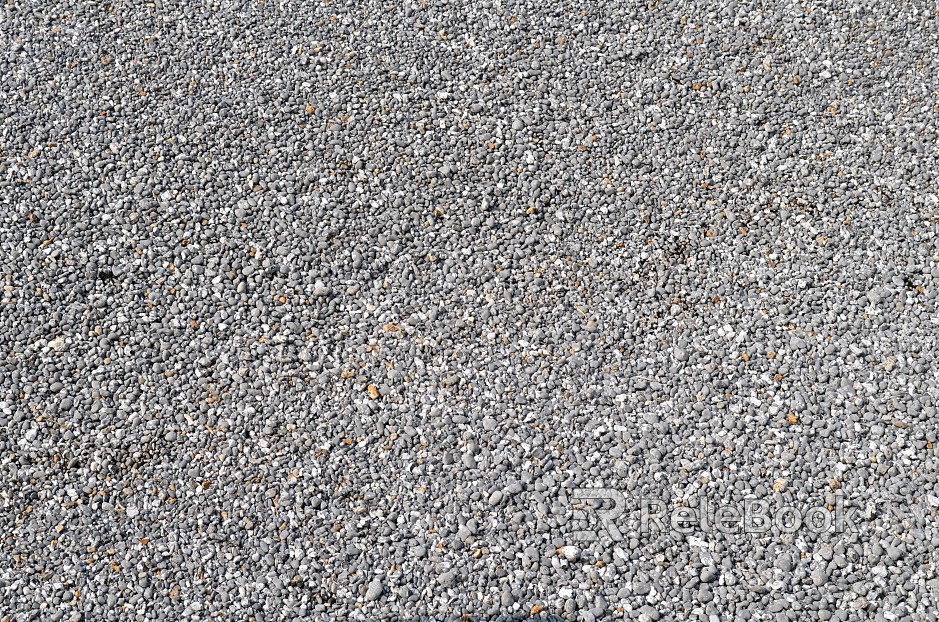 A gritty, textured image of gravel, showcasing small stones and pebbles in shades of gray, brown, and black, set against a contrasting backdrop.