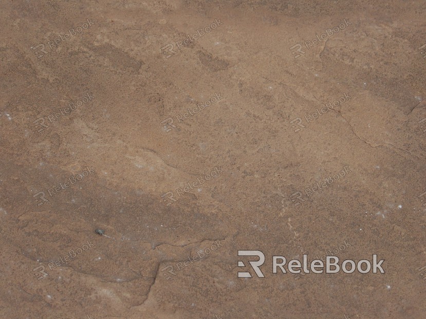 A rugged, gray-brown boulder textured with rough, uneven surfaces and cracks, set against a blurred background.