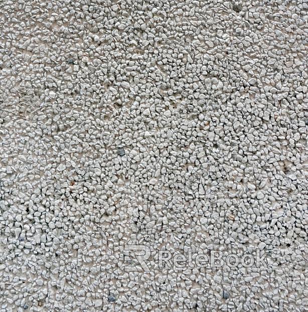 The image depicts a close-up of gravel, showcasing a mix of small, irregularly shaped stones in various shades of gray and brown, set against a contrasting dark background.