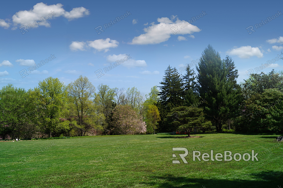 A breathtaking view of a vast, snow-capped mountain range under a clear blue sky, with wispy clouds adding to the serene atmosphere. The rugged peaks and lush greenery in the foreground create a stunning contrast.