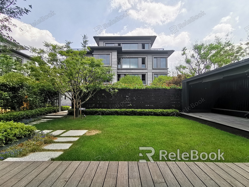 A charming residential exterior featuring a white, two-story facade with black shutters, complemented by a sloping roof and a spacious, well-manicured front lawn.