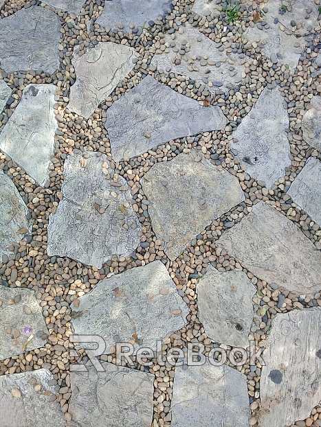 Close-up of stone paving, revealing its textured surface with irregular, interlocking pieces of natural stone in various shades of gray and brown, creating a rustic and durable pathway material.