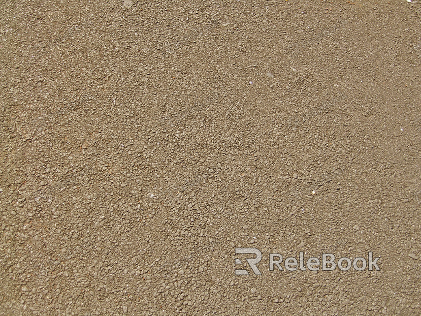 A coarse, granular material, this image showcases a textured surface of gravel, comprised of various sizes of small stones and pebbles, predominantly in shades of gray and brown.