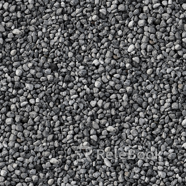 A gritty, textured image of gravel, showcasing small stones and pebbles in various shades of gray and brown, set against a backdrop of what appears to be a concrete or asphalt surface.