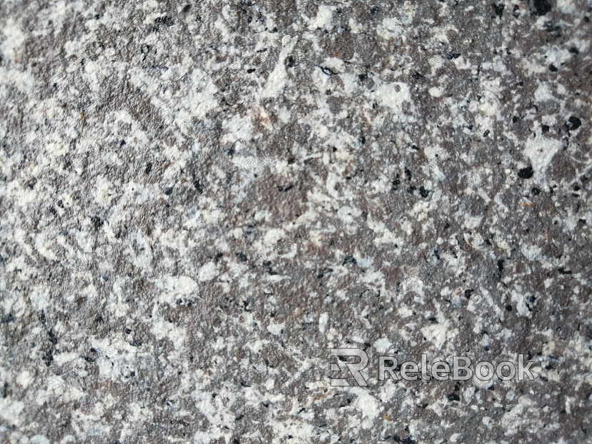 A close-up texture shot of granite, showcasing its characteristic flecks of white, grey, and black in a rugged, natural pattern. The stone's crystalline structure is evident in the varied grain sizes and colors.