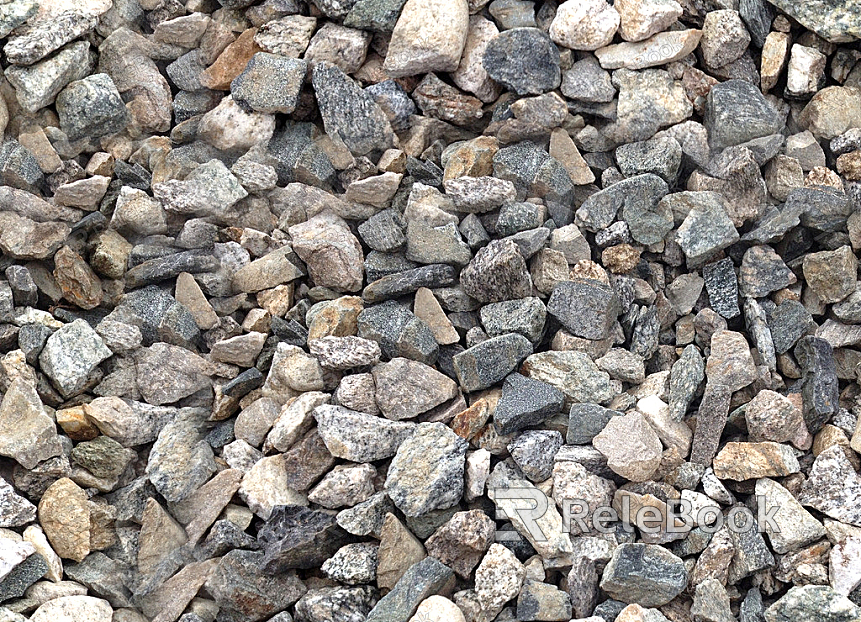 The image depicts a close-up of gravel, showcasing an assortment of small, irregularly shaped stones with hues of gray, brown, and black, set against a contrasting background.