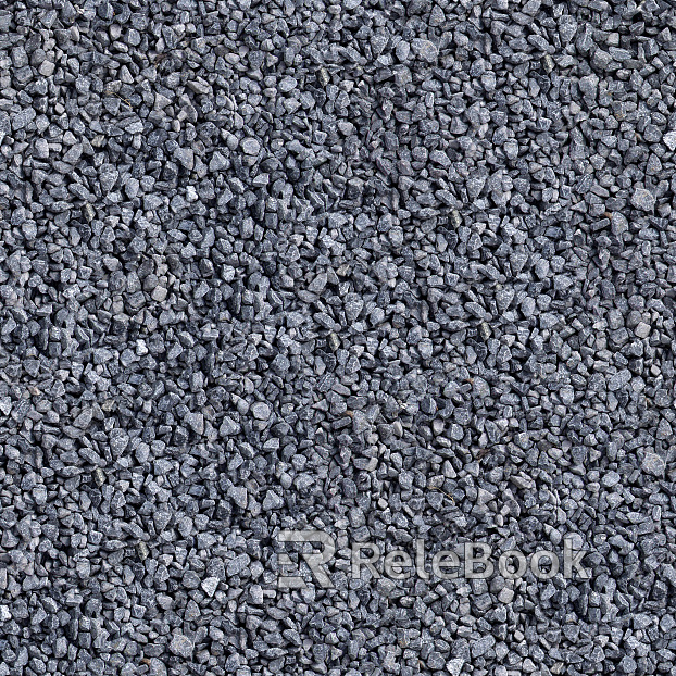 A coarse, granular material consisting of fragments of rock and mineral, varying in color from grey to brown, scattered on a flat surface, forming a typical gravel texture.